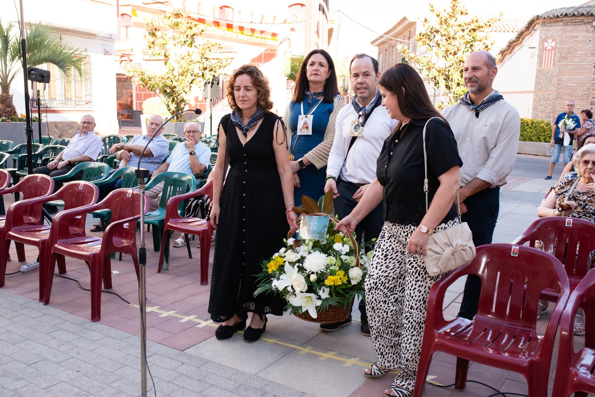 Grupo de vecinos con una cesta de flores en la Ofrenda Floral de Herencia