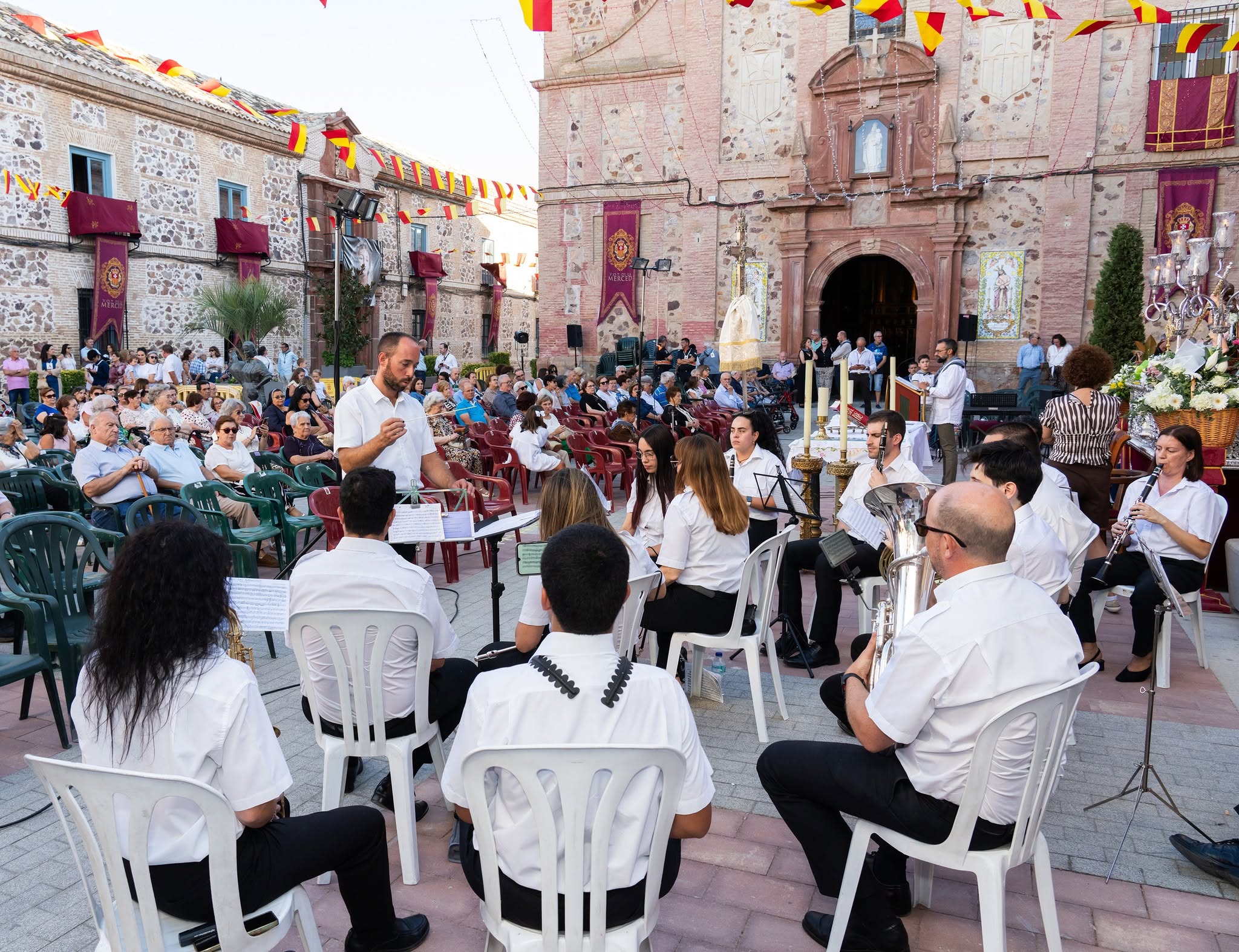 Plano general de la plaza de Herencia durante la Ofrenda Floral, con la iglesia al fondo