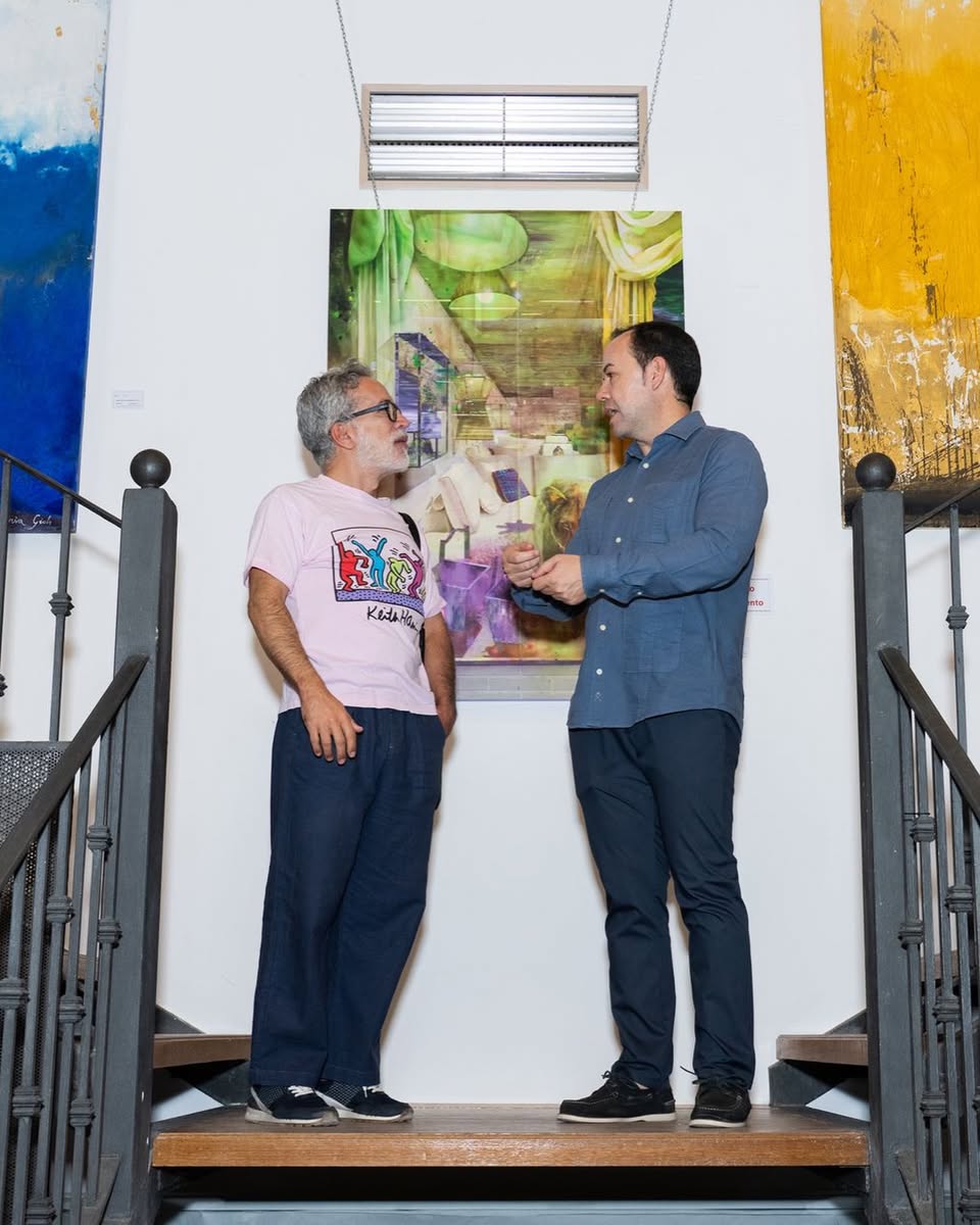 Dos asistentes conversan en la escalera de la sala de exposiciones